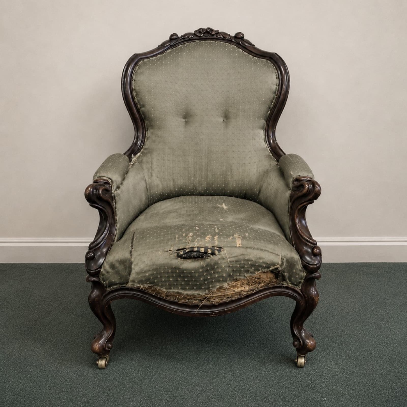 Victorian armchair before restoration, worn and torn pale green fabric